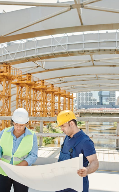 Construction professionals reviewing blueprints at a large metal building site in Spring Branch, Texas