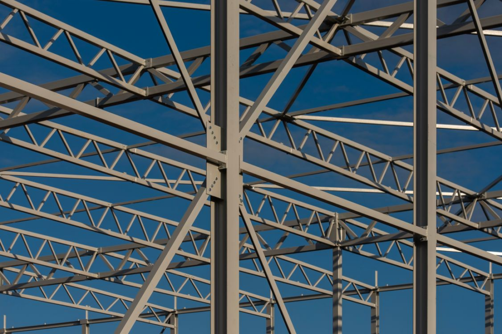 Detailed view of a steel framework structure against a blue sky, showcasing modern construction elements