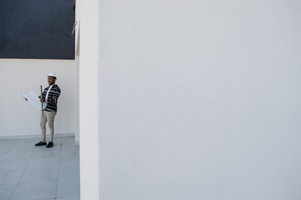 a project manager standing at a construction site reviewing a schedule