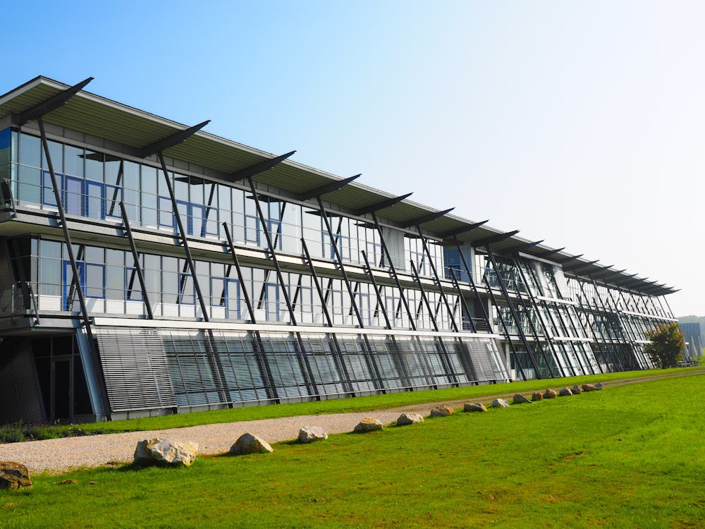 A large steel building with a field nearby.