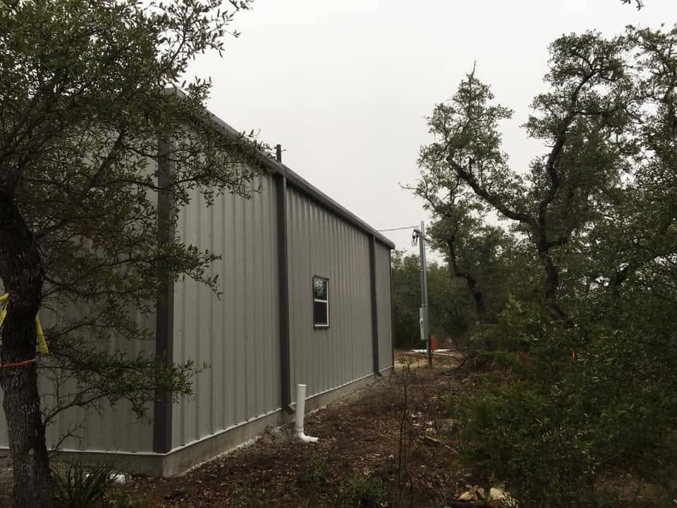 Trees surrounding a metal building 