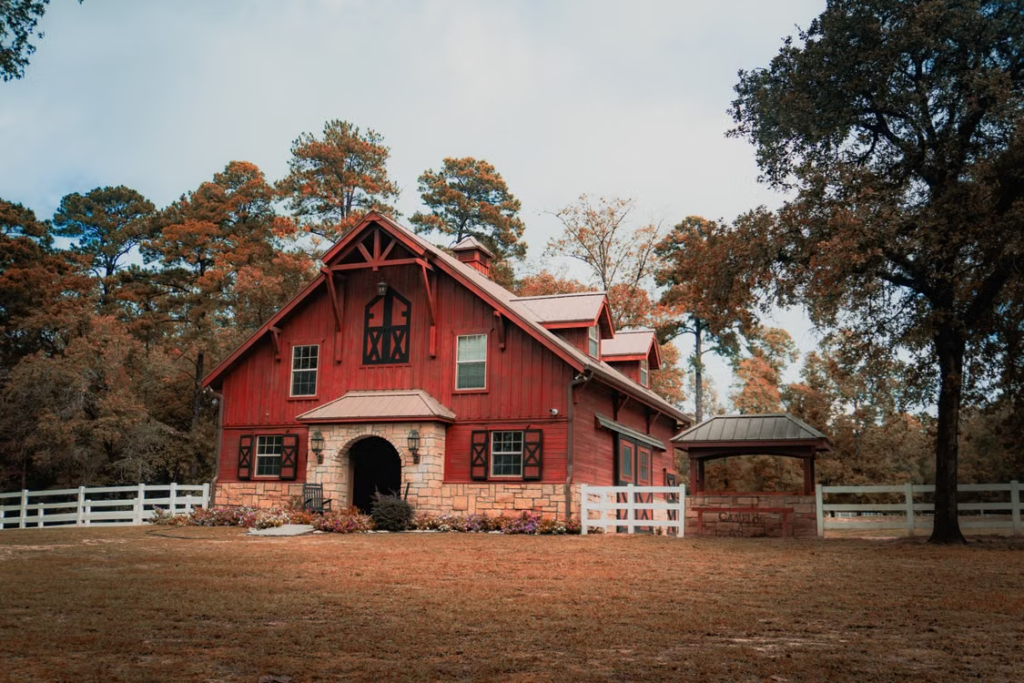 A large barndominium with a huge backyard.